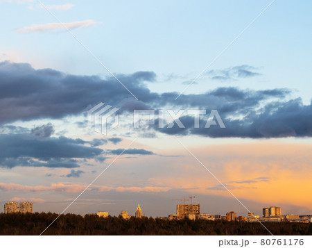 dark clouds in blue sky over houses at sunset 80761176