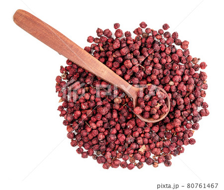 top view of spoon on magnolia berries on white 80761467