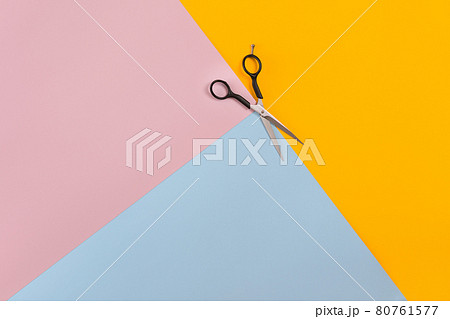 Scissors on the color pink, yellow, blue paper background. Top view. 80761577
