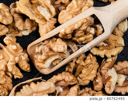 top view of wooden scoop on peeled walnuts 80762493