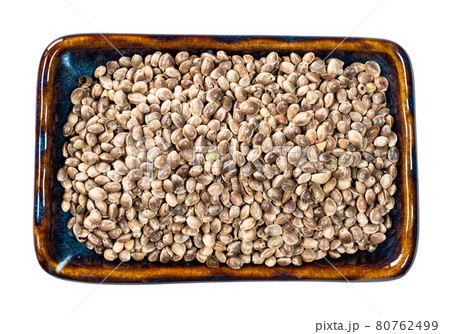 top view of unpeeled hemp seeds in bowl cutout 80762499