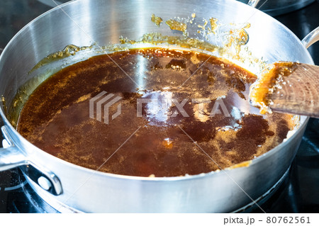cooking salted butter caramel sauce at home kitchen - melted sugar in steel pan cooking salted butter caramel sauce at home kitchen - melted sugar in steel pan 80762561