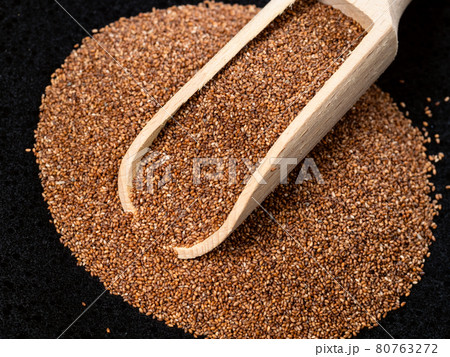 scoop on pile of wholegrain teff seeds on black 80763272