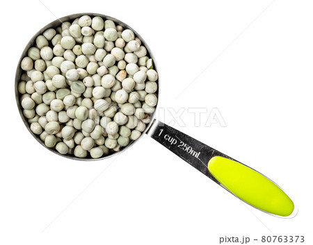 dried whole green peas in measuring cup cutout 80763373