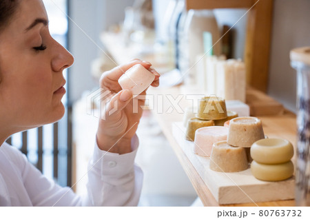 Woman sniffing organic soap while choosing at eco friendly store. 80763732