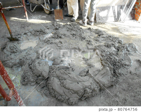 MALACCA, MALAYSIA -AUGUST 24, 2016: Construction workers manually mixing cement, sand and water to form mortar for brick and plastering work. MALACCA, MALAYSIA -AUGUST 24, 2016: Construction workers manually mixing cement, sand and water to form mortar for brick and plastering work. 80764756