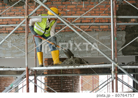 MALACCA, MALAYSIA -AUGUST 24, 2016: Construction workers manually mixing cement, sand and water to form mortar for brick and plastering work. MALACCA, MALAYSIA -AUGUST 24, 2016: Construction workers manually mixing cement, sand and water to form mortar for brick and plastering work. 80764757