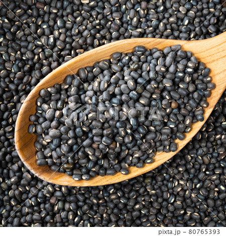 whole black urad beans in wooden spoon closeup whole black urad beans in wooden spoon closeup 80765393