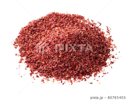 handful of sumac powder closeup on white 80765403
