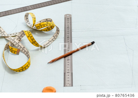 measure tape, rulers and pencil on pattern layout 80765436