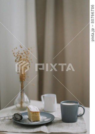 Morning breakfast with a piece of fresh homemade cake with a cup of cappuccino on a table with linen tablecloth.  80766786