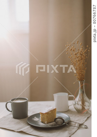 Morning breakfast with a piece of fresh homemade cake with a cup of cappuccino on a table with linen tablecloth.  80766787