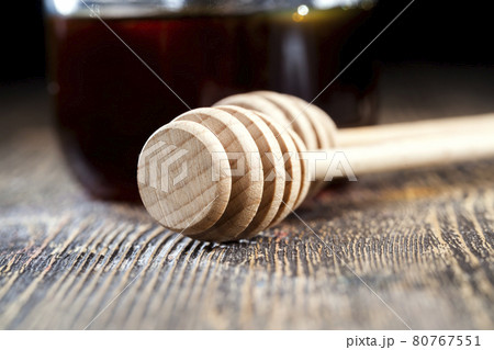 a spoon for honey together with high-quality bee honey a spoon for honey together with high-quality bee honey 80767551