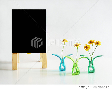 プラスチッククリップに挟んだ黄色い花と黒色の立て看板のコピースペース 80768237