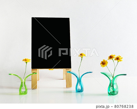 プラスチッククリップに挟んだ黄色い花と黒色の立て看板のコピースペース 80768238