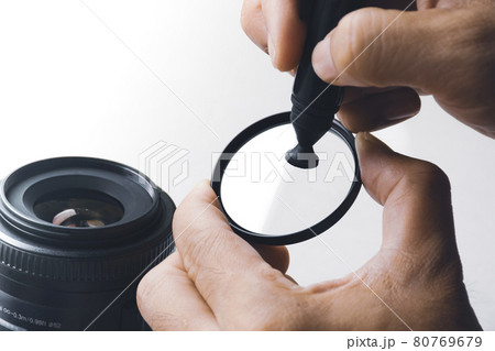 Human hand cleaning stain on UV filter of camera lens with carbon brush cleaner 80769679