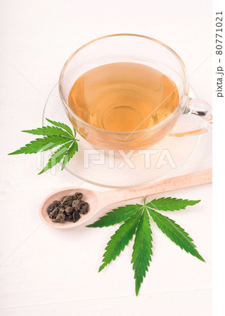 Cannabis herbal tea and green marijuana leaves Cannabis herbal tea and green marijuana leaves 80771021