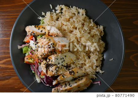 Spicy chicken on stir rice with salad and vegetables top view 80771490