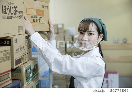 スーパーのバックヤードでマウスシールドをして作業をする女性従業員 スーパーのバックヤードでマウスシールドをして作業をする女性従業員 80772842