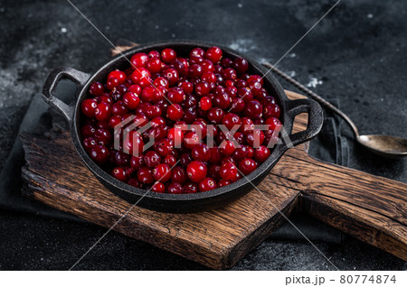 Red fresh Cranberry berry in a pan. Black background. Top view Red fresh Cranberry berry in a pan. Black background. Top view 80774874