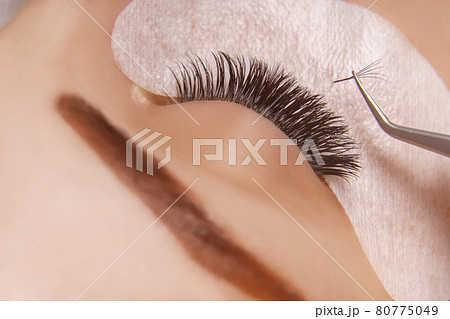 Eyelash Extension Procedure. Woman Eye with Long Eyelashes. Close up, selective focus. 80775049