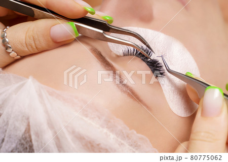 Eyelash Extension Procedure. Woman Eye with Long Eyelashes. Close up, selective focus. 80775062