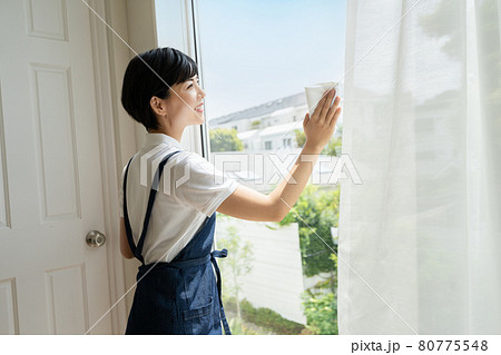 窓の拭き掃除をする若い女性 窓の拭き掃除をする若い女性 80775548