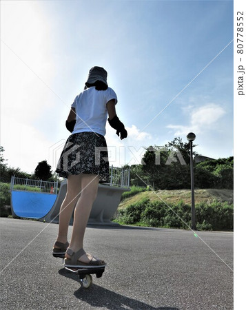 スケートボードに乗って公園で遊ぶ活発な女の子 80778552