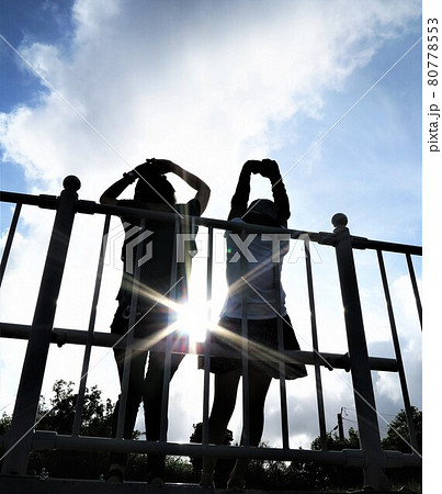 公園でベンチに座る仲良し親子　母と娘の楽しい会話に差し込む明るい光 80778553