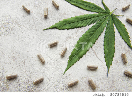 CBD pills. Group of clear CBD Cannabidiol capsules and hemp leaf CBD pills. Group of clear CBD Cannabidiol capsules and hemp leaf 80782616