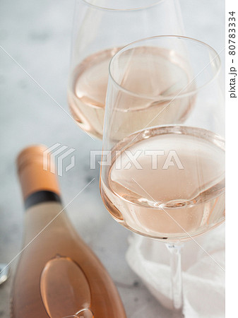 Two crystal glasses and bottle of pink rose homemade wine on light background. 80783334