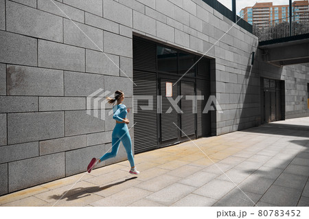 Beautiful fit young woman jogger is running outdoors Beautiful fit young woman jogger is running outdoors 80783452