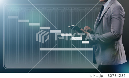 Business Man use Digital Tablet to check schedule and strategy Project Planning for future market demand. Screen show projection plan by week for success period, dark background 80784285