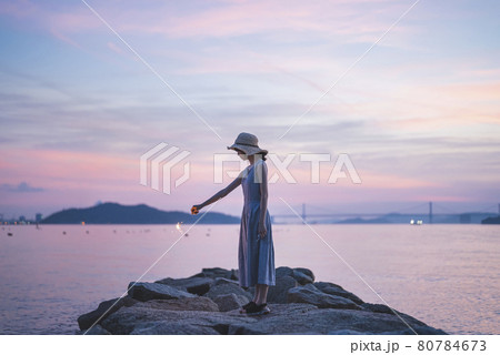 夕暮れの海で花火をする女性 80784673