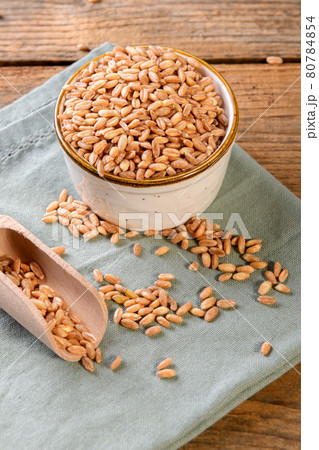 Wholegrain uncooked raw spelt farro in bowl on the wooden background Wholegrain uncooked raw spelt farro in bowl on the wooden background 80784854