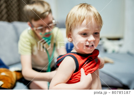 Two boys 11 years old and 3 years old playing doctor and patient at home. Two boys 11 years old and 3 years old playing doctor and patient at home. 80785187