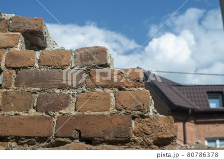 Old brown brick wall against the blue sky. 80786378