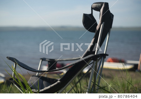 Camping folding chair against the backdrop of the lake. Camping folding chair against the backdrop of the lake. 80786404