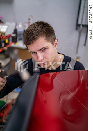 Close shot of dent removing without paint, using rubber hammer  80786599