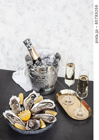 Champagne glasses with sparkling wine and bottle in bucket near oysters Champagne glasses with sparkling wine and bottle in bucket near oysters 80789266