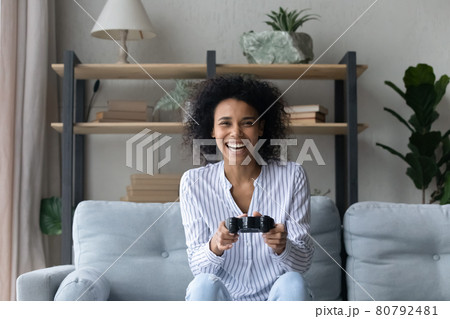 Smiling African American woman play video game 80792481