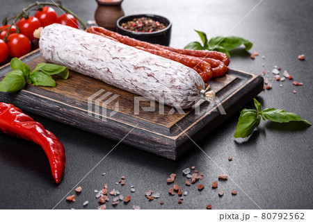 Spanish dried sausage salami on a dark concrete background 80792562