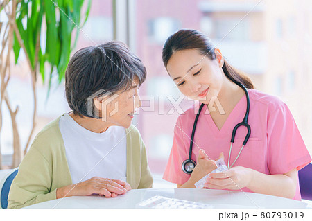 薬ケースの説明をする介護スタッフ 80793019