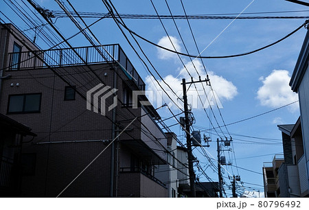 様々なケーブルや電線とそれらを支える電柱 80796492