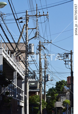 様々なケーブルや電線とそれらを支える電柱 80796497