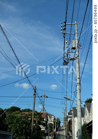 様々なケーブルや電線とそれらを支える電柱 80796499