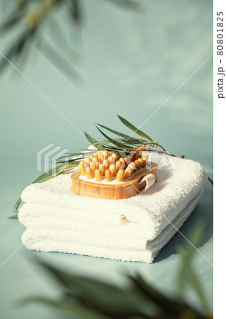Massage wooden brush on white spa towels with eucalyptus leaves Massage wooden brush on white spa towels with eucalyptus leaves 80801825