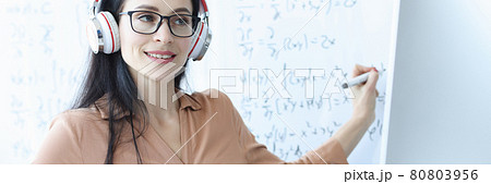 Woman teacher with headphones conducts online math class 80803956