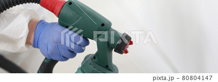 Gloved hand of master holds spray gun Gloved hand of master holds spray gun 80804147