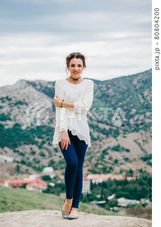 happy traveler girl is standing in the mountains 80804200